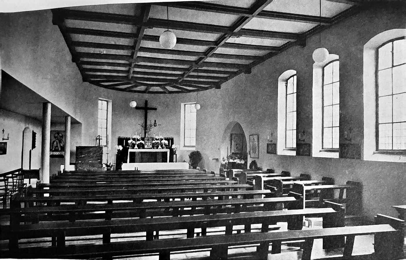 Innenraum der alten Kirche mit Holzdecke, Bänken und Altar